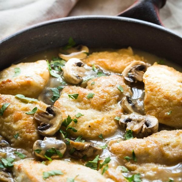 30 Minute Paleo Chicken Marsala recipe made with chicken, mushrooms, marsala wine, chicken broth and garnished with parsley. Thickened with arrowroot (or use cornstarch if you are not paleo) and you can serve it over mashed potatoes or zoodles