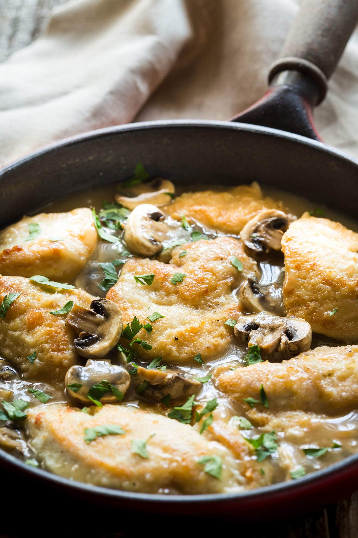 30 Minute Paleo Chicken Marsala recipe made with chicken, mushrooms, marsala wine, chicken broth and garnished with parsley. Thickened with arrowroot (or use cornstarch if you are not paleo) and you can serve it over mashed potatoes or zoodles