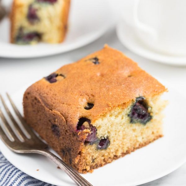 slice of gluten free blueberry cake on a white plate