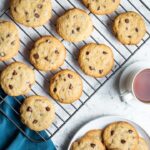 gluten free chocolate chip cookies on a baking sheet and on a plate with a cup of tea