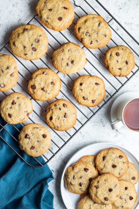 gluten free chocolate chip cookies on a baking sheet and on a plate with a cup of tea
