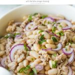 Tuna White Bean Salad with Red Wine vinaigrette dressing, and no mayo! It's packed full of protein and contains, tuna, white beans and fresh parsley. A really healthy, gluten free, low calorie lunch or dinner option, this salad is ready to eat in less than 5 Minutes! dairy free, egg free, gluten free www.noshtastic.com #glutenfreesalad #healthysalad #tunasalad #whitebeansalad #tuna #cleaneating #healthyeating