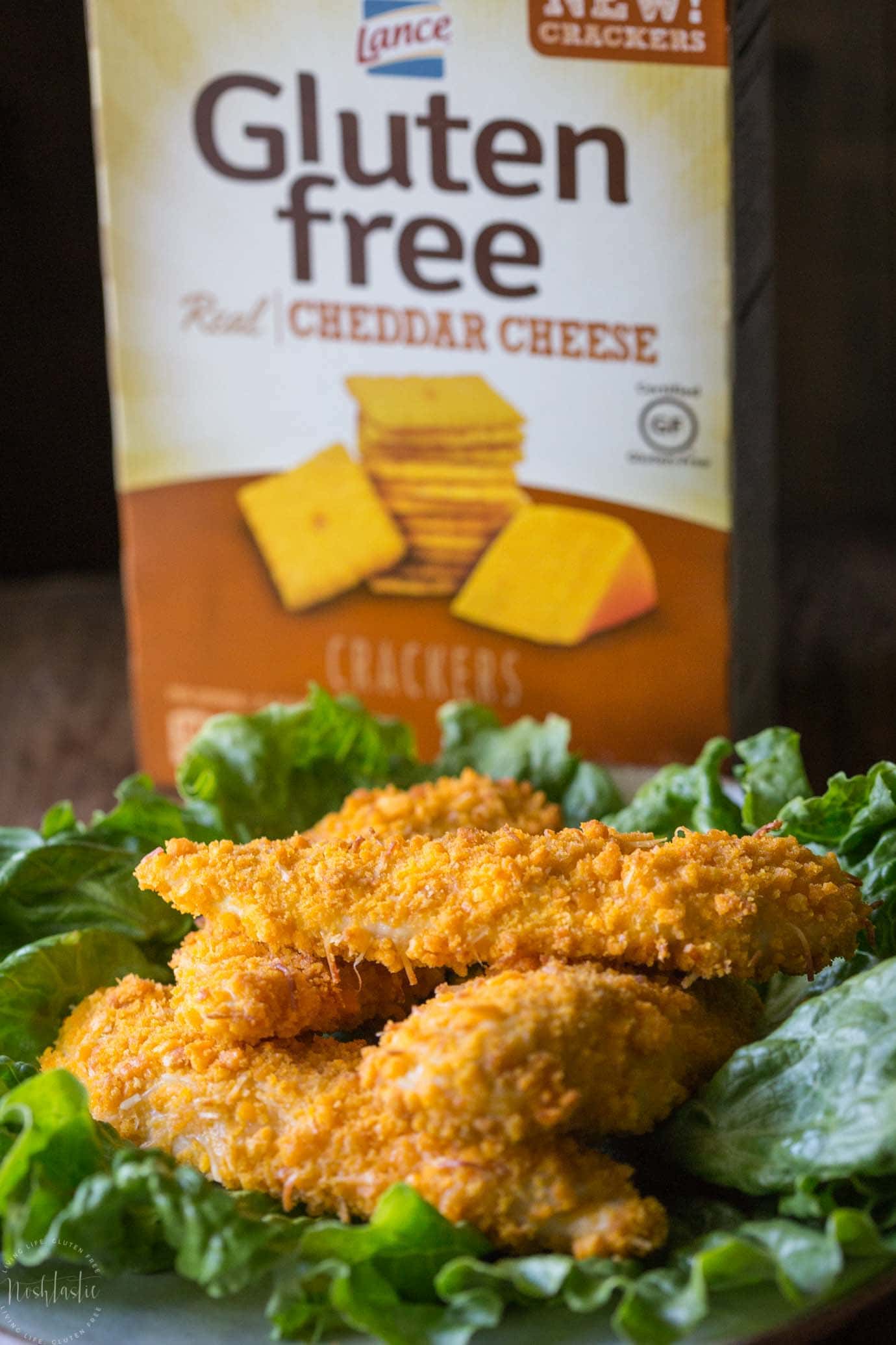 gluten free chicken tenders on plate with box of crackers in the background