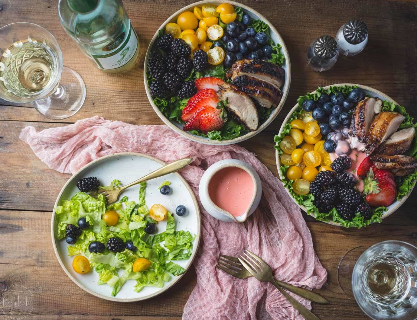 Overhead photo of Grilled Balsamic Chicken Salad Bowls on a table with Strawberry Vinaigrette