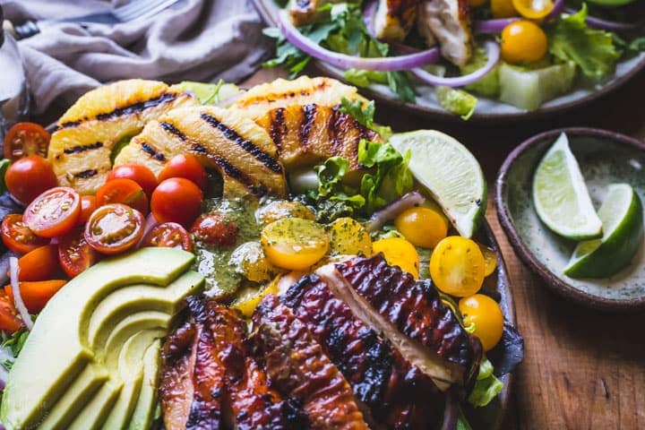 Cilantro Lime Chicken Salad, made with grilled pineapple, red onions, avocado, cherry tomatoes and served on a bed of lettuce. Healthy, Paleo and W30.