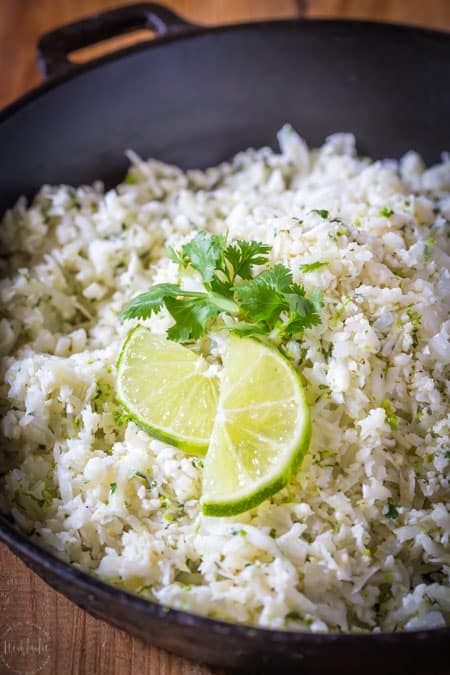 Paleo Cilantro Lime Cauliflower Rice is a fantastic substitute for real rice, it has way less calories and is perfect for people on a low carb or ketogenic diet. #keto #ketogenicdiet #lowcarb #cauliflowerrice #paleo #whole30 #glutenfree #cilantro #lime #lowcalorie #castironskillet