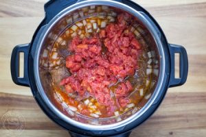 pot roast, taco spices and tomatoes in a pressure cooker