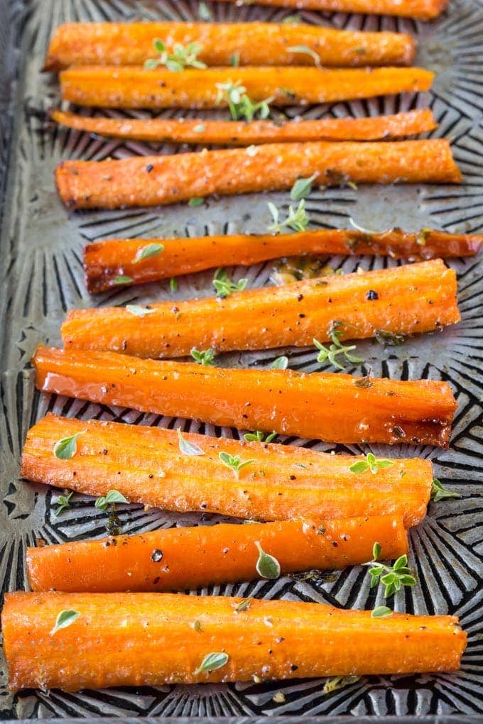 Quick and easy Paleo glazed carrots made with honey, olive oil and fresh thyme. You can cook them on the stovetop or bake them in the oven! #paleo #paleosides #paleocarrots #glutenfree
