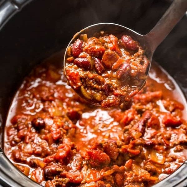 Slow Cooker Chili recipe - easy to make, this Crockpot chili is bursting with flavor and combines Ancho chili powder and fire roasted tomatoes to create an amazing flavor combination! #chilirecipe #crockpotrecipes #slowcookerrecipes #chiliconcarne #beefrecipes #beefchilirecipes #groundbeef #glutenfree #noshtastic