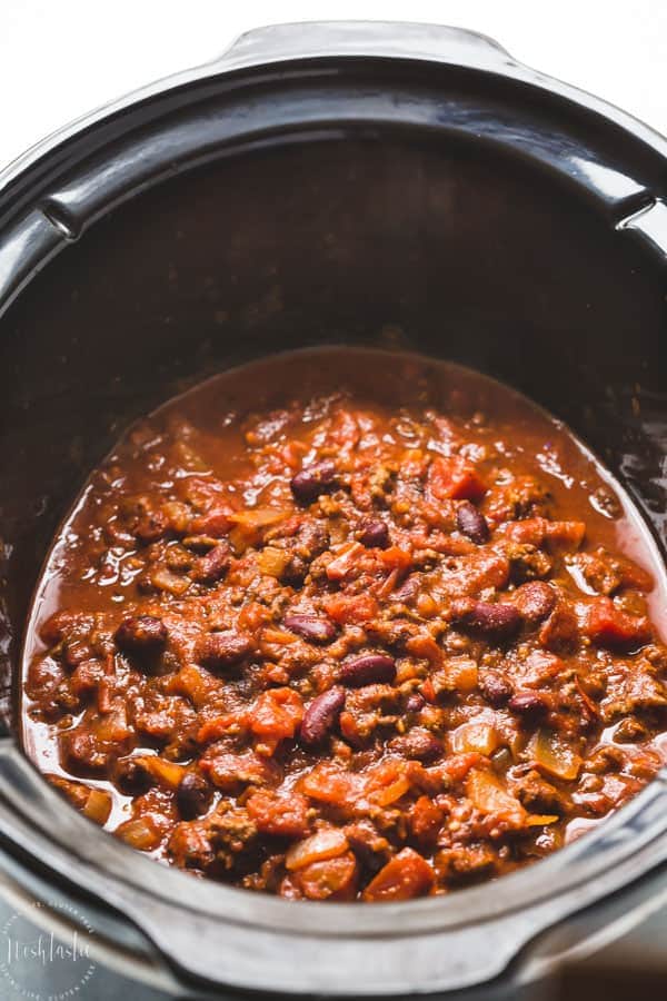 Slow Cooker Chili recipe - easy to make, this Crockpot chili is bursting with flavor and combines Ancho chili powder and fire roasted tomatoes to create an amazing flavor combination! #chilirecipe #crockpotrecipes #slowcookerrecipes #chiliconcarne #beefrecipes #beefchilirecipes #groundbeef #glutenfree #noshtastic