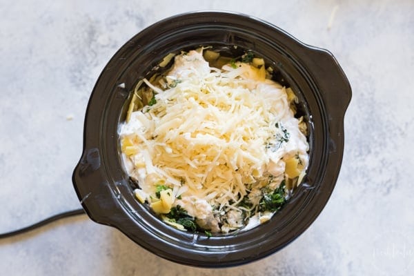 spinach and artichoke dip recipe in your crockpot or slow cooker! Made with cheese, spinach and artichoke hearts #spinachartichokedip #gameday #gamedayrecipes #chipsanddip #cheesedip #crockpotdip #partyfood #appetizer #noshtastic #glutenfree #glutenfreeappetizer