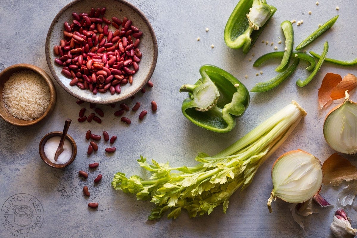 dried red kidney beans in a bowl with fresh vegetables nearby