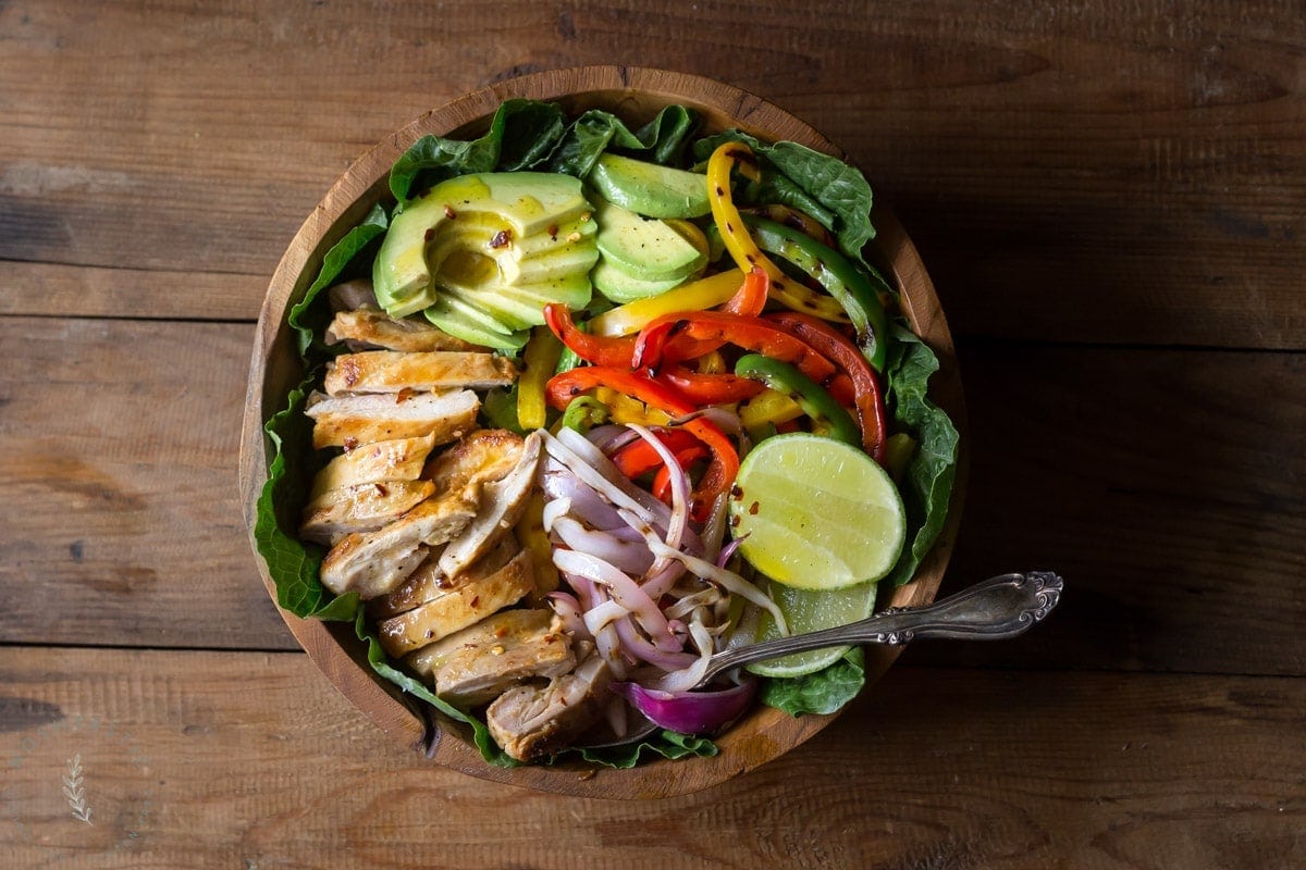 My Chicken Fajita Salad has all kinds of tasty ingredients including, grilled marinated fajita chicken, red onions, bell pepper, avocados and is topped with a fabulous honey lime salad dressing.| www.noshtastic.com | #chickenfajitas #chickenfajitasalad #fajitasalad #chickensalad #paleo #paleosalad #paleochicken #healthysalad #glutenfree #noshtastic #glutenfreerecipe 