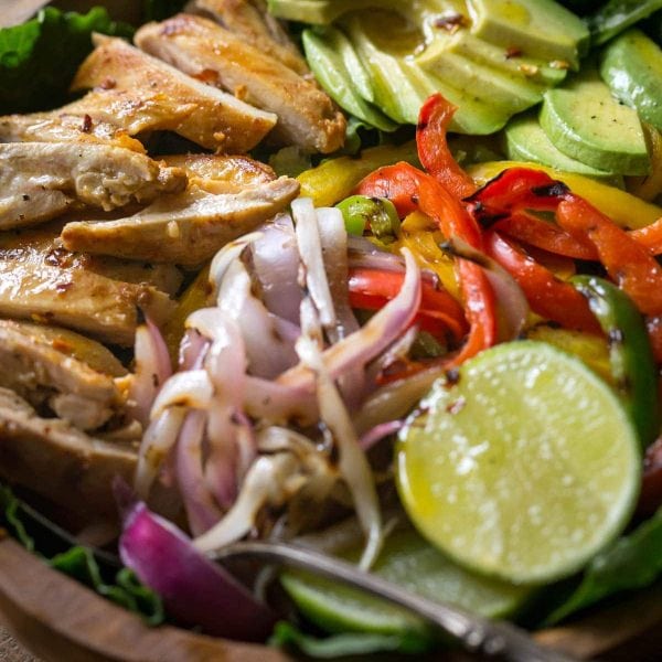 My Chicken Fajita Salad has all kinds of tasty ingredients including, grilled marinated fajita chicken, red onions, bell pepper, avocados and is topped with a fabulous honey lime salad dressing.| www.noshtastic.com | #chickenfajitas #chickenfajitasalad #fajitasalad #chickensalad #paleo #paleosalad #paleochicken #healthysalad #glutenfree #noshtastic #glutenfreerecipe