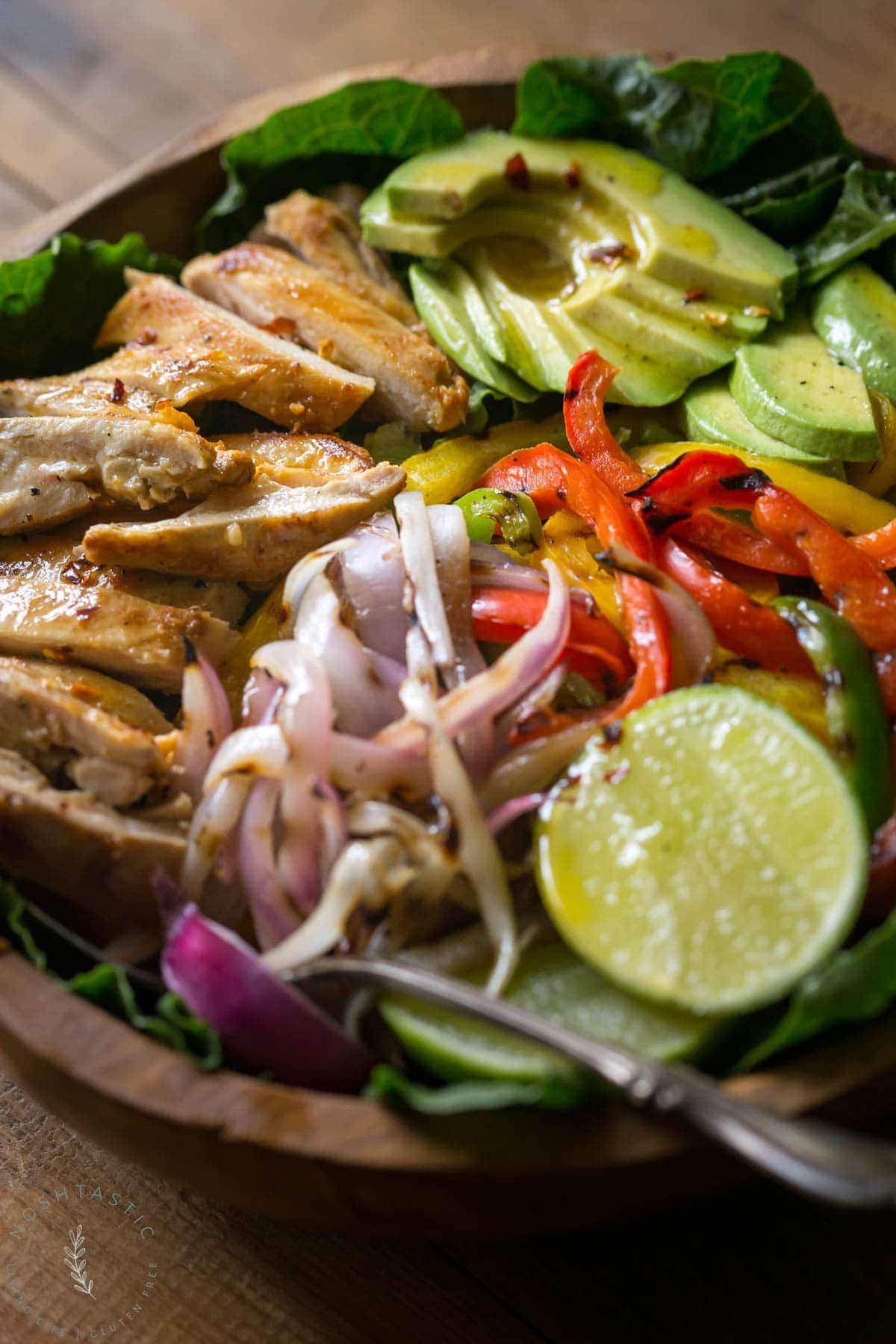 My Chicken Fajita Salad has all kinds of tasty ingredients including, grilled marinated fajita chicken, red onions, bell pepper, avocados and is topped with a fabulous honey lime salad dressing.| www.noshtastic.com | #chickenfajitas #chickenfajitasalad #fajitasalad #chickensalad #paleo #paleosalad #paleochicken #healthysalad #glutenfree #noshtastic #glutenfreerecipe 