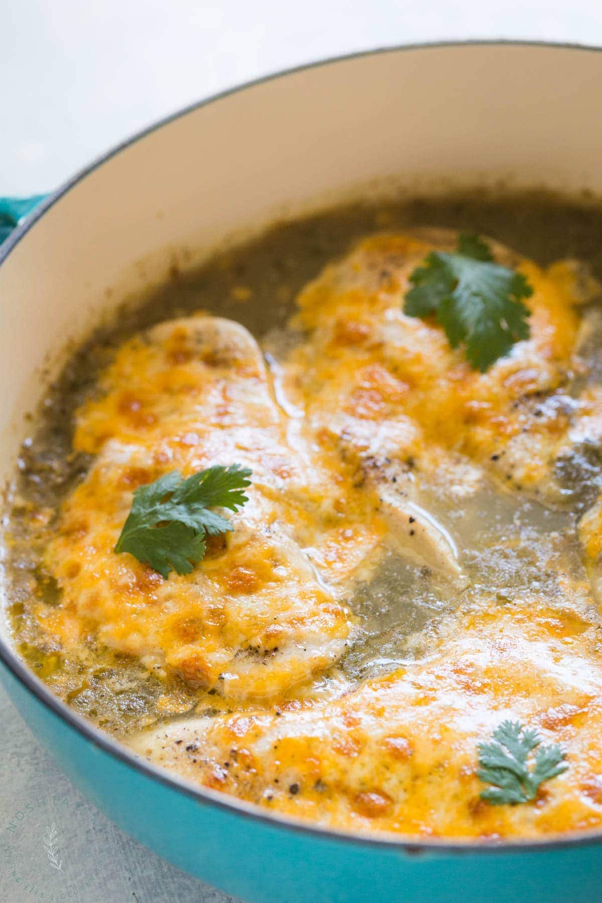salsa verde chicken in a pan with cheese