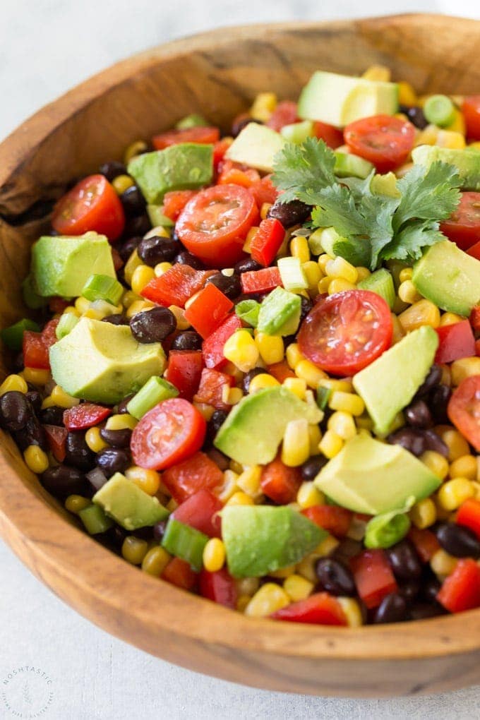 avocado corn salad with tomatoes in a bowl