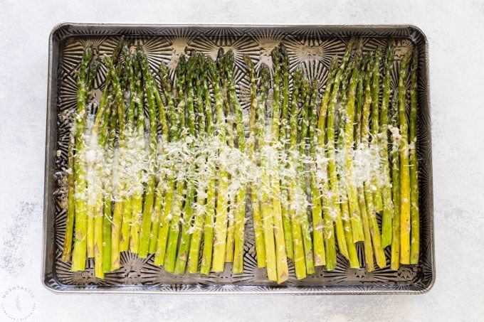 asparagus on a sheet pan with parmesan cheese