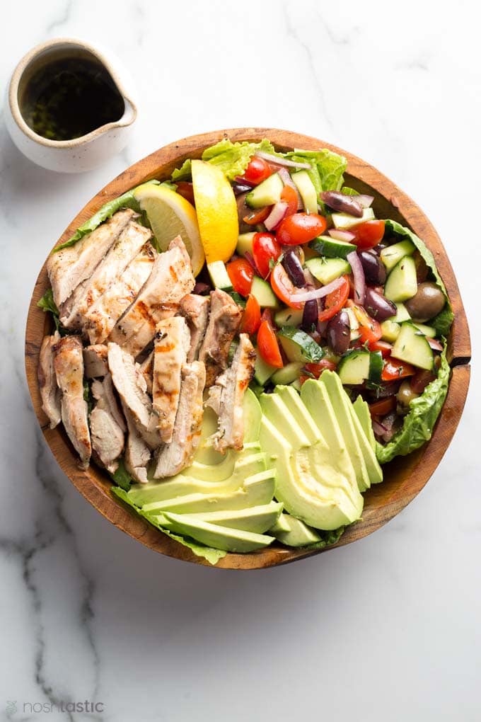 chicken salad in a bowl with dressing on the side