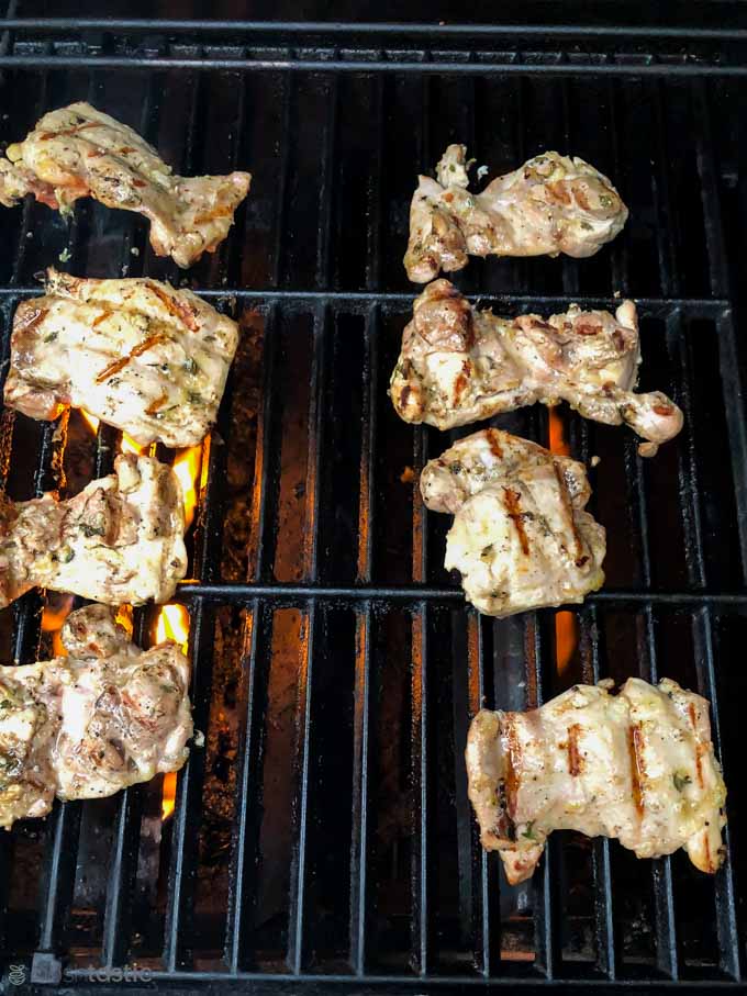 Chicken thigh fillets cooking on a gas grill