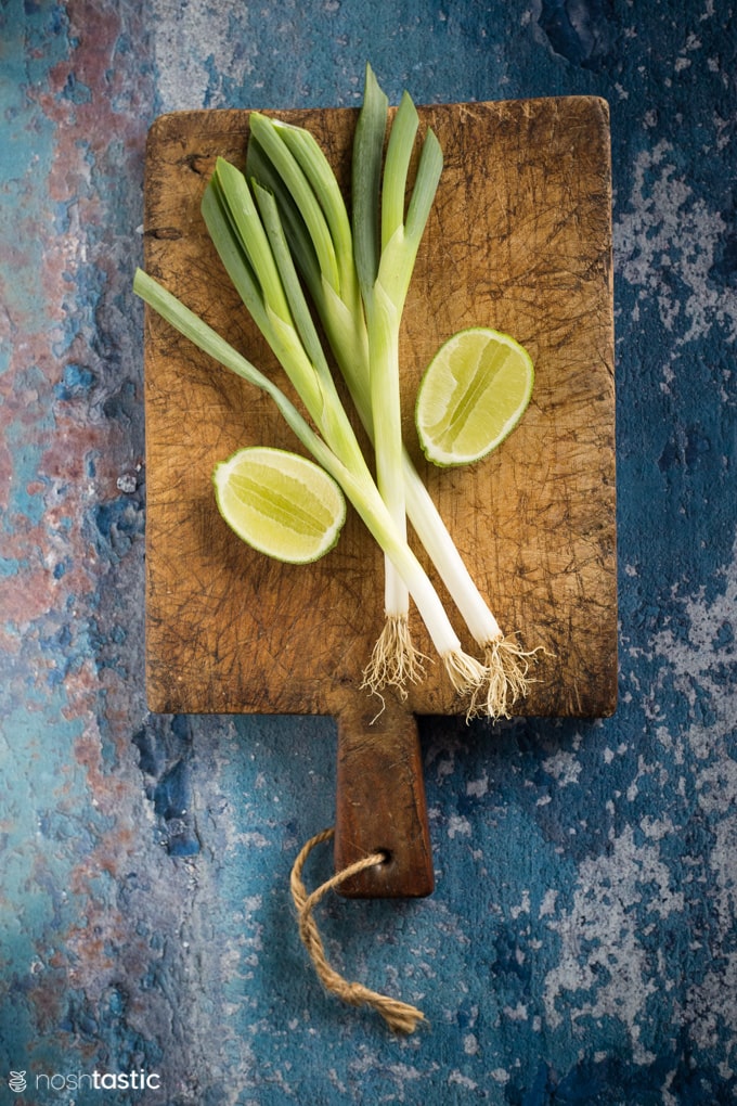 limes and green onions on a plate