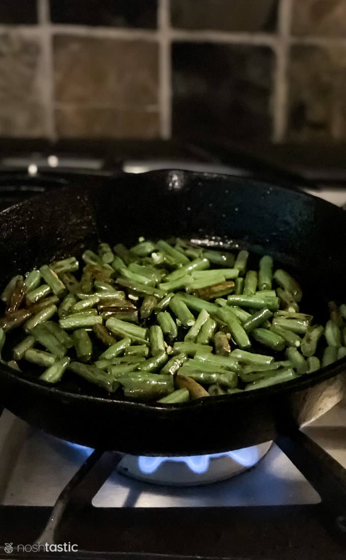 charred green beans in a skillet