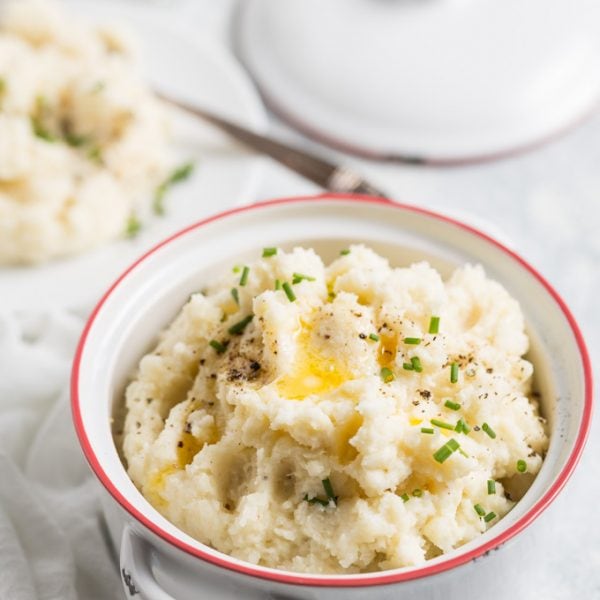 cauliflower mash in a bowl with melted butter on top