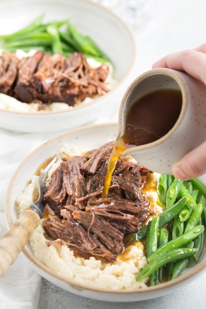 Pot roast in a bowl with green beans and gravy