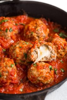 Mozzarella meatballs in a cast iron skillet with marinara sauce