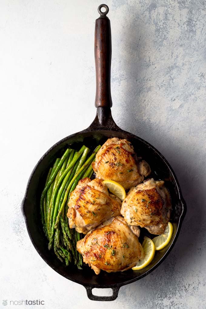 Pan cooked lemon thyme chicken thighs with asparagus and lemon slices