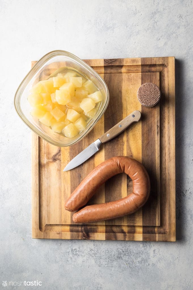 Ingredients for sausage pineapple bites on a board