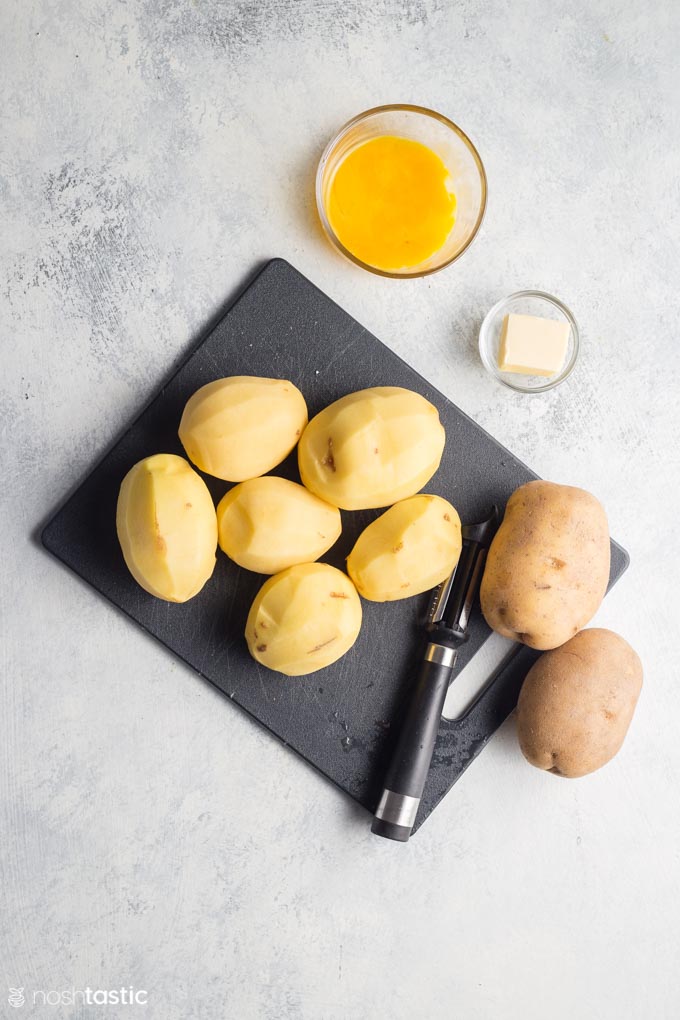 Peeled potatoes on a cutting board for making duchess potatoes