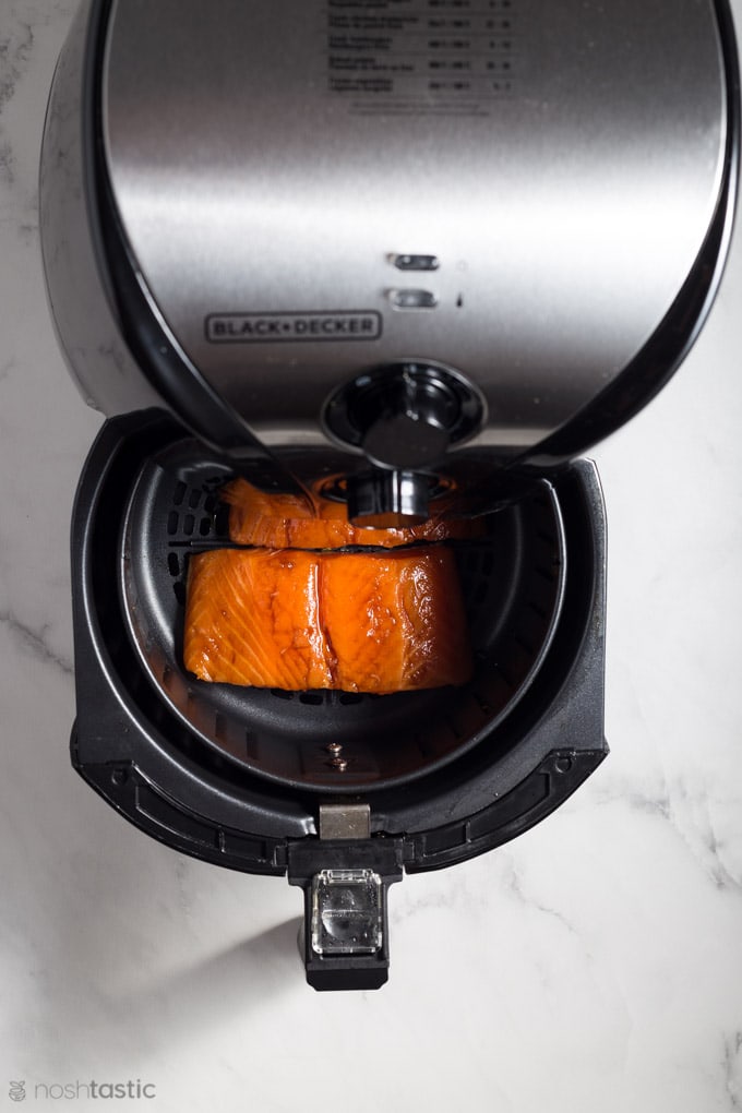 Salmon in the drawer of an air fryer waiting to be cooked