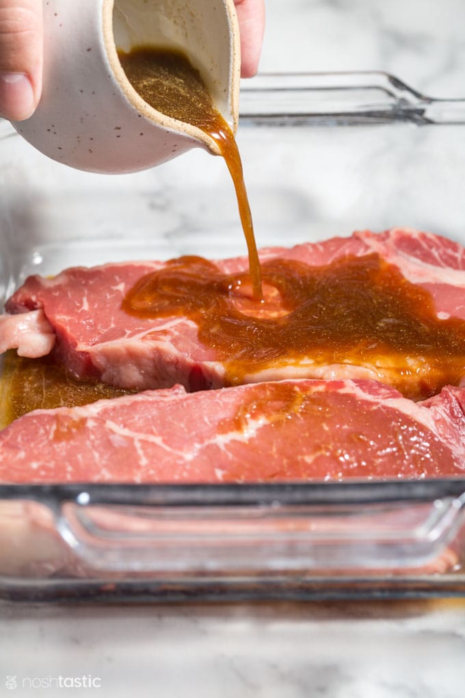 marinade being poured over steaks in a dish