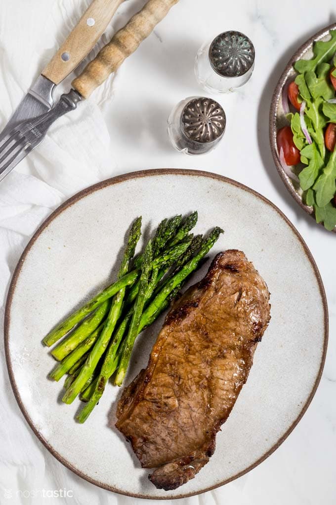 Air fried steak on a plate with asparagus