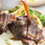 Instant pot short ribs on a plate with gravy poured over