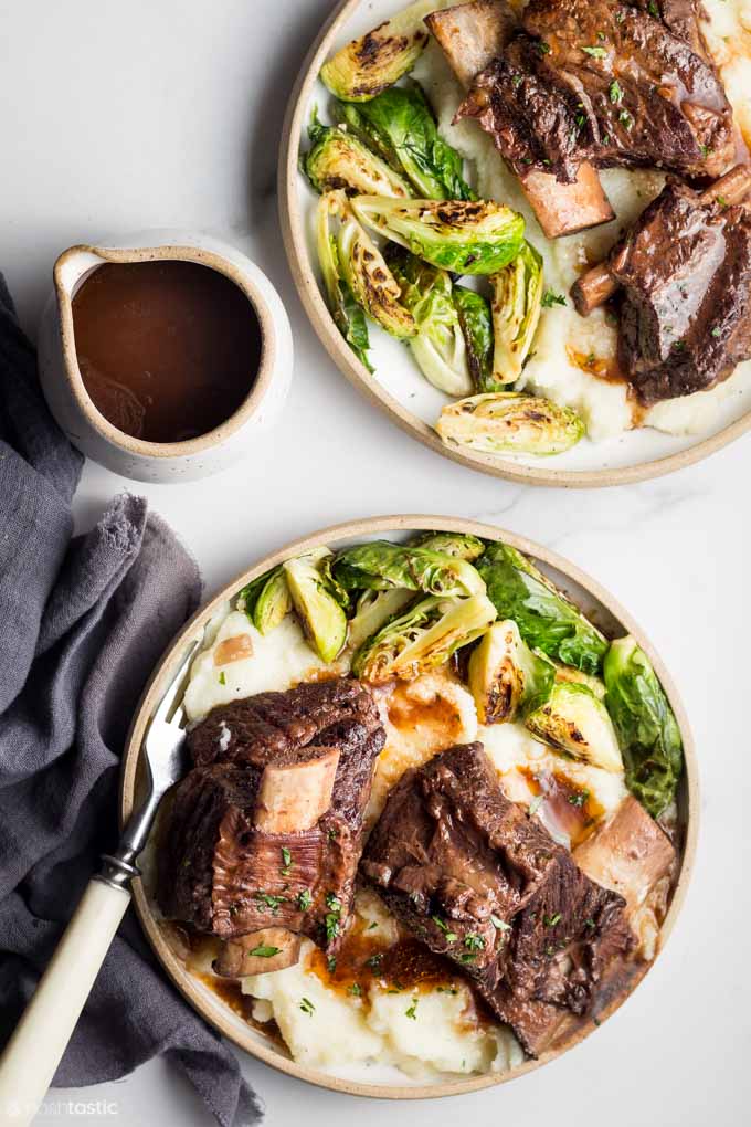 two bowls of short ribs with gravy and mashed potatoes