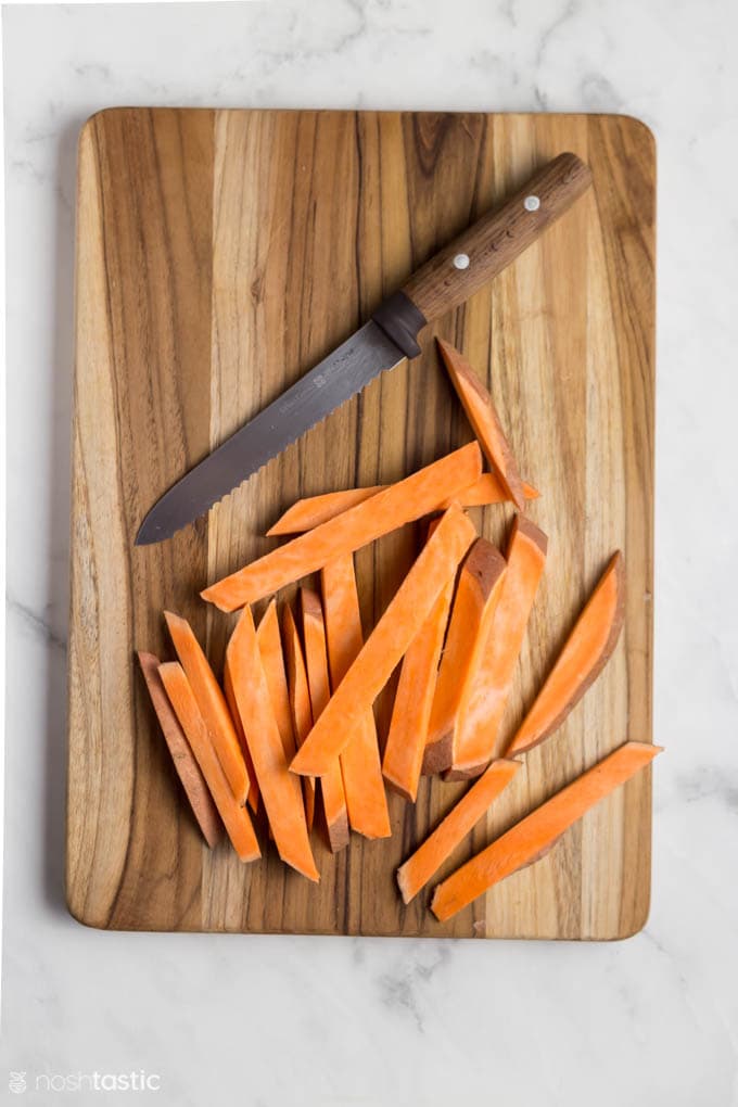 sweet potato fries on a board with a knife