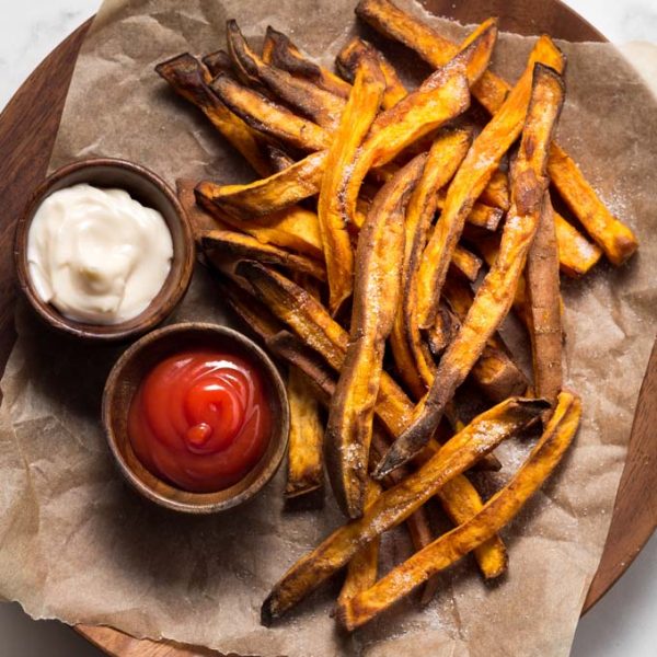 sweet potato fries on a plate with ketchup and mayo