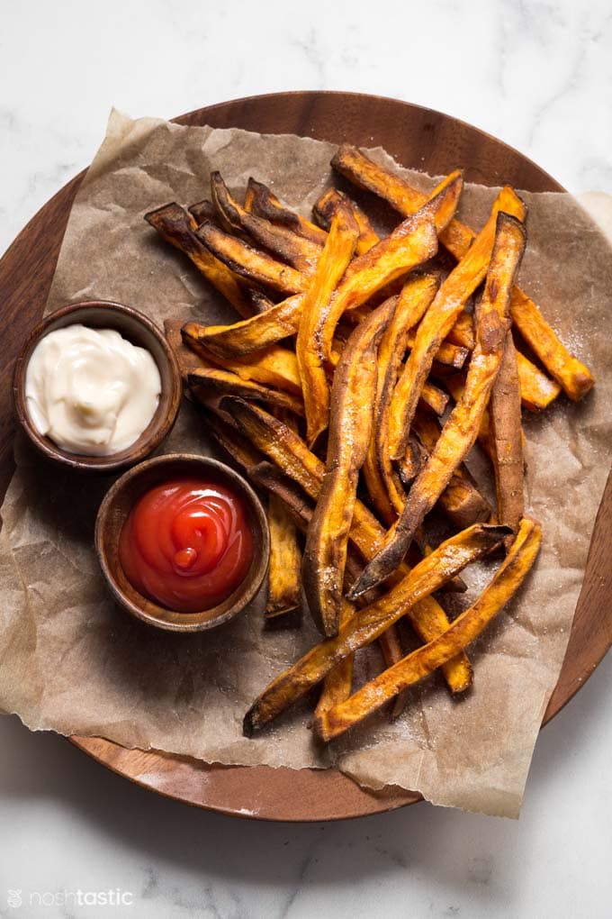 sweet potato fries on a plate with ketchup and mayo