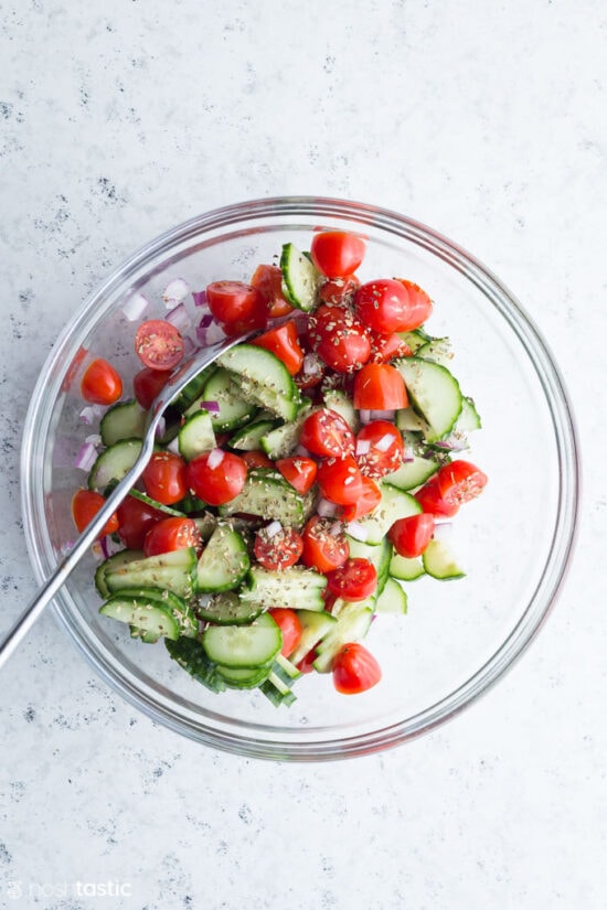 cucumber and tomato in a bowl with herbs