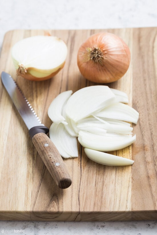 sliced onions on a board with knife