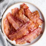 slices of cooked bacon on a plate with napkin