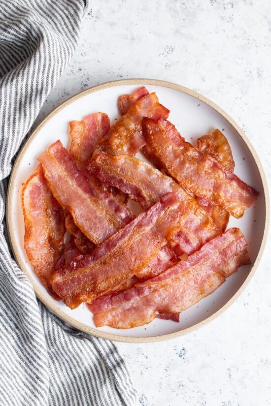 slices of cooked bacon on a plate with napkin