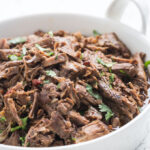 Shredded barbacoa beef in a white dish