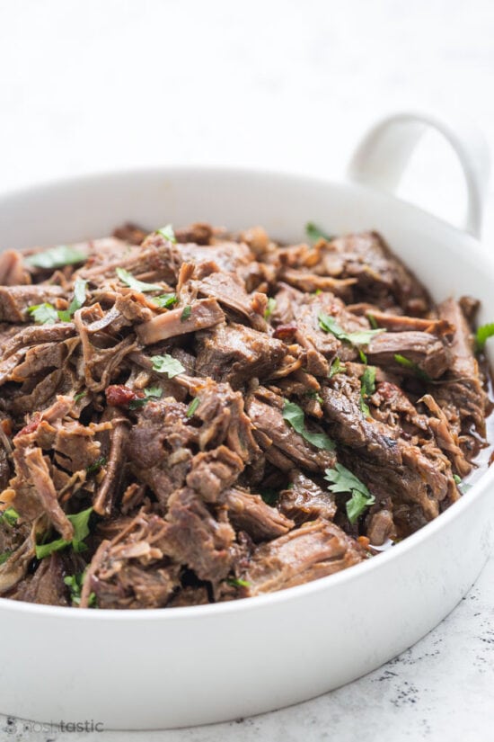 Shredded barbacoa beef in a white dish