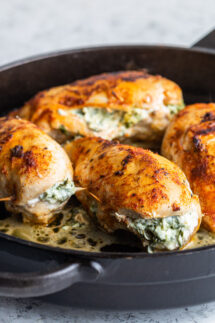 chicken stuffed with spinach in a skillet