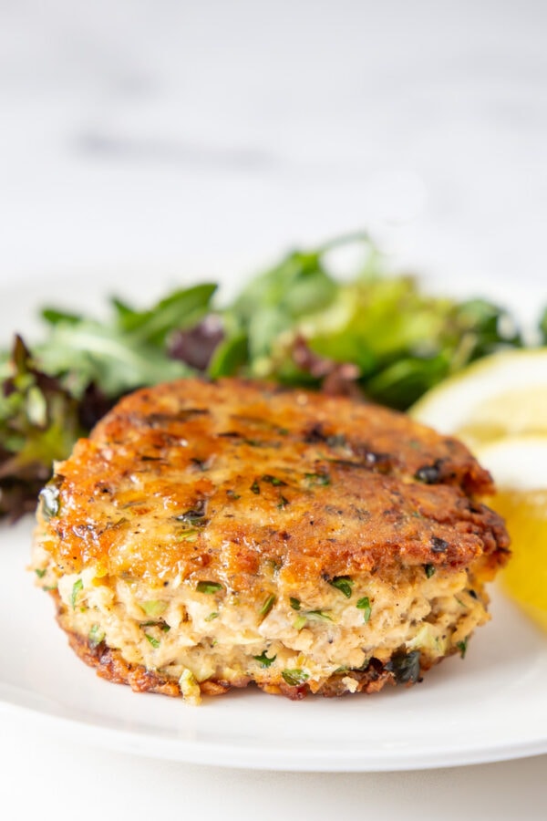 Salmon patty on a plate with salad